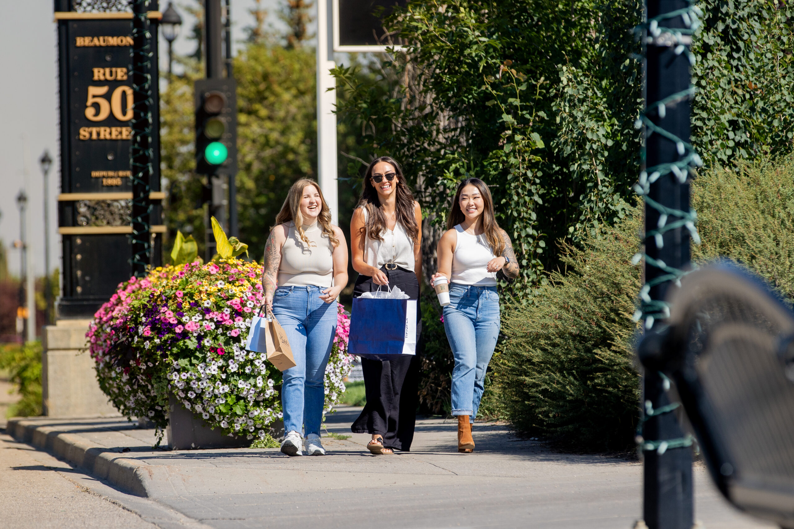 Sunny sidewalk scene in downtown Beaumont of three women walking together.